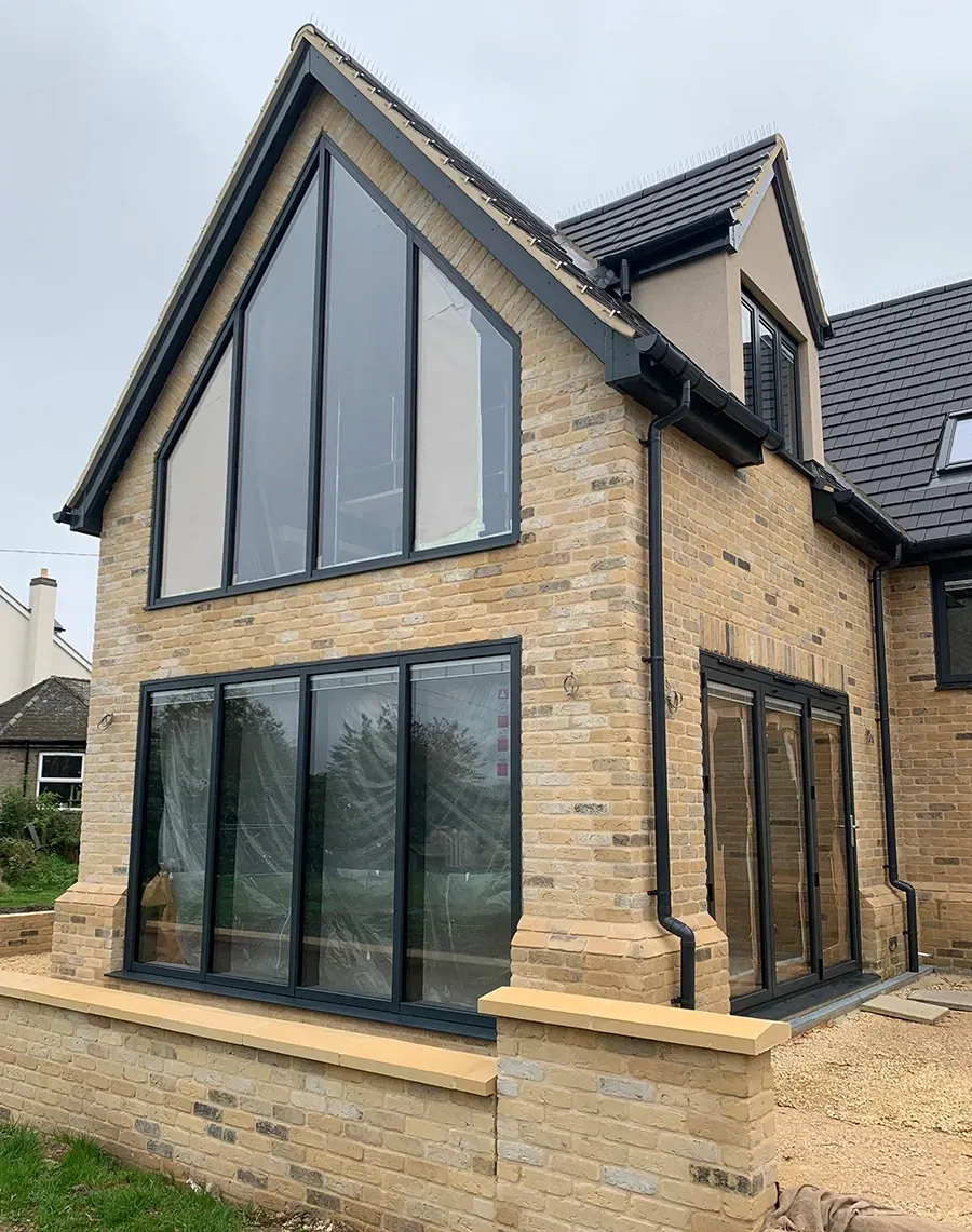 A large brick house with a lot of windows and a black roof.