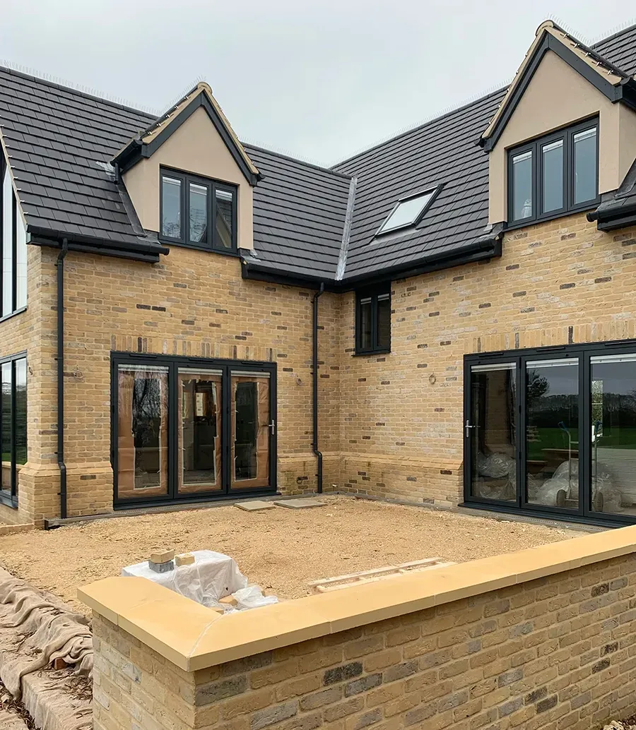A large brick house with a black roof and a lot of windows.