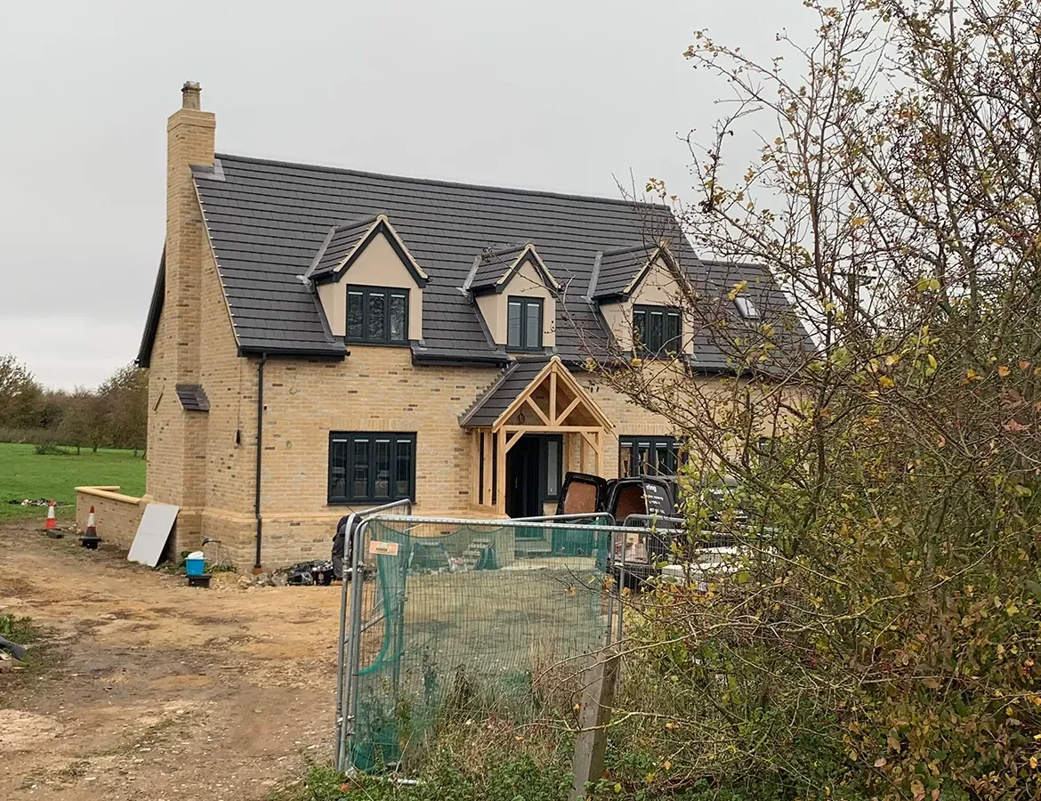 A large house is being built in the middle of a field.
