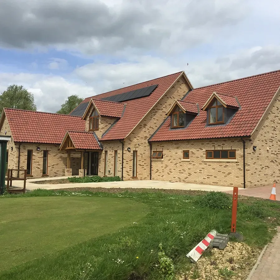A large brick house with a red tiled roof