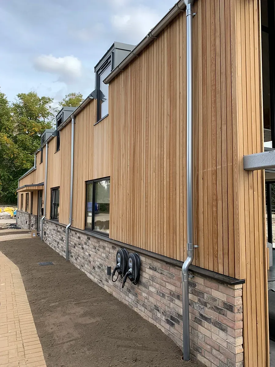 A large building with a wooden siding and a brick wall.