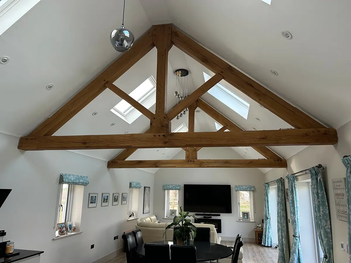 A living room with a vaulted ceiling and wooden beams