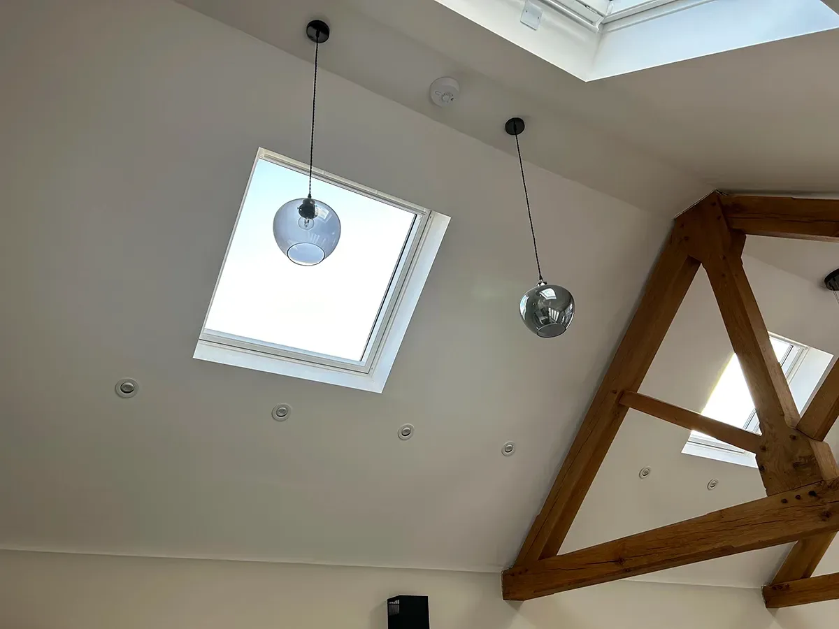 A ceiling with two skylights and a disco ball hanging from the ceiling.