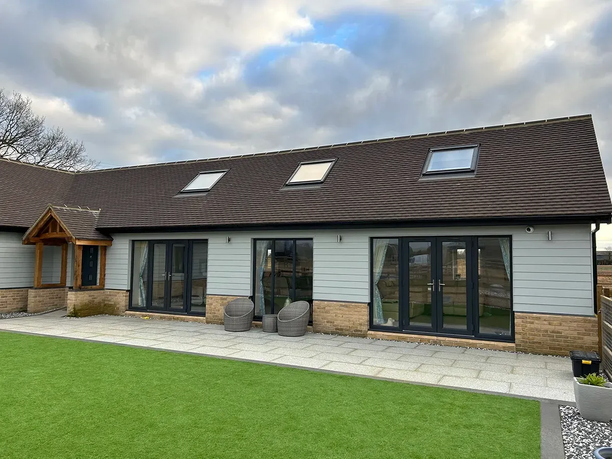 A large house with a lot of windows and a patio in front of it.