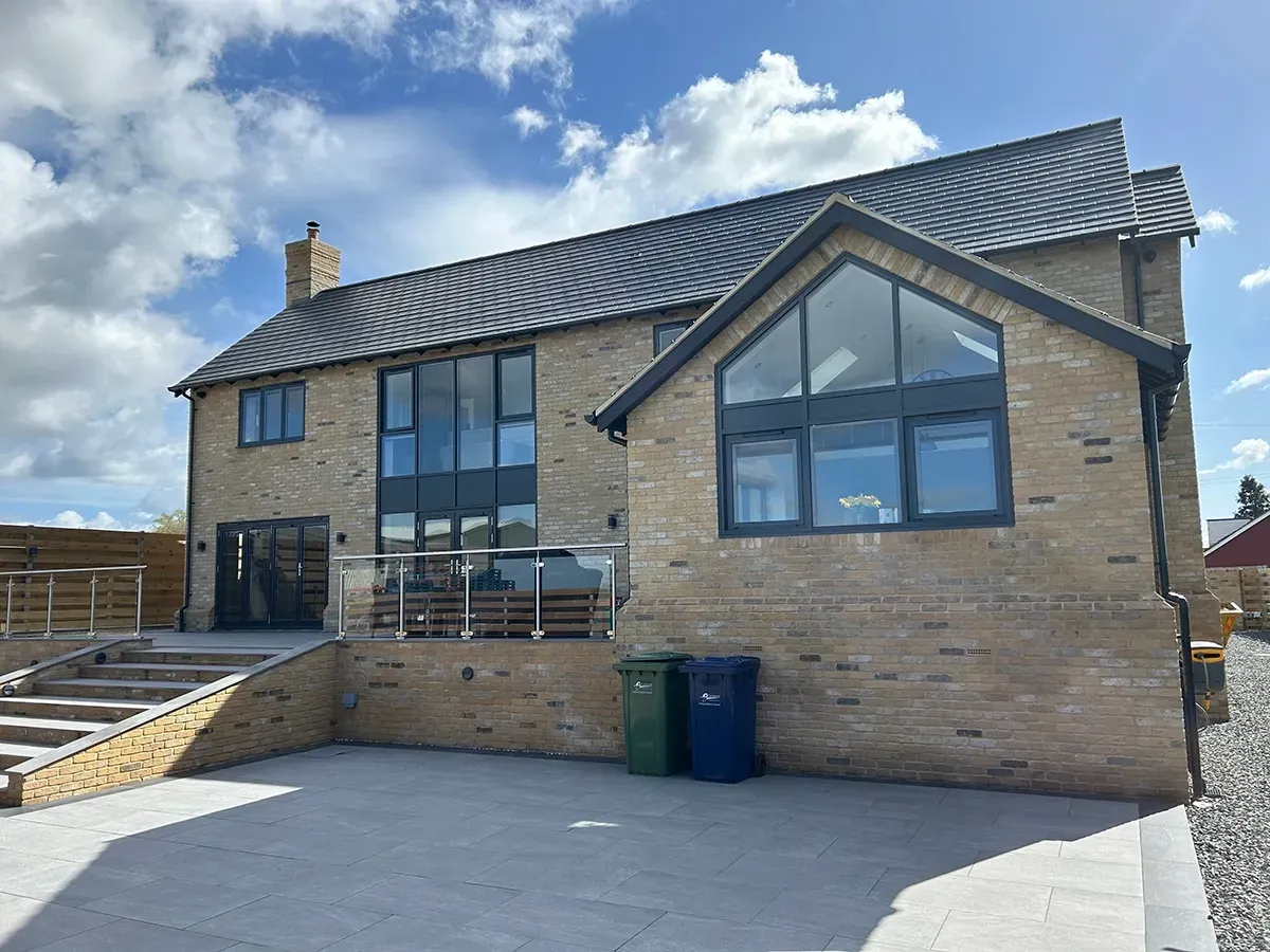 A large brick house with a lot of windows and a patio.