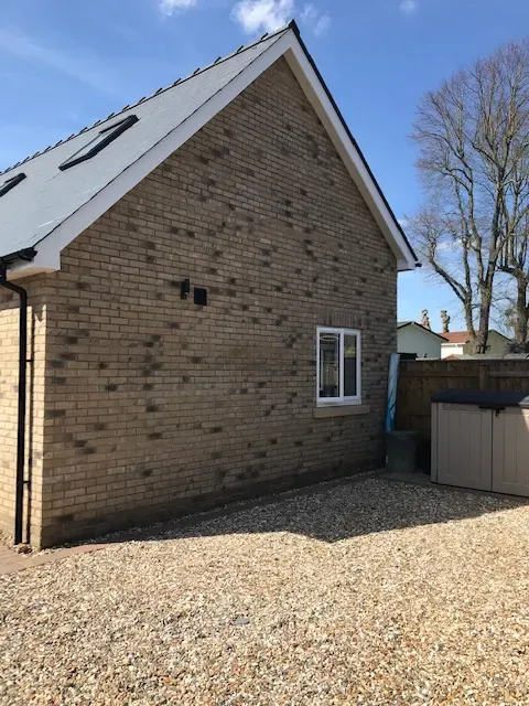 A brick house with a white roof and a window