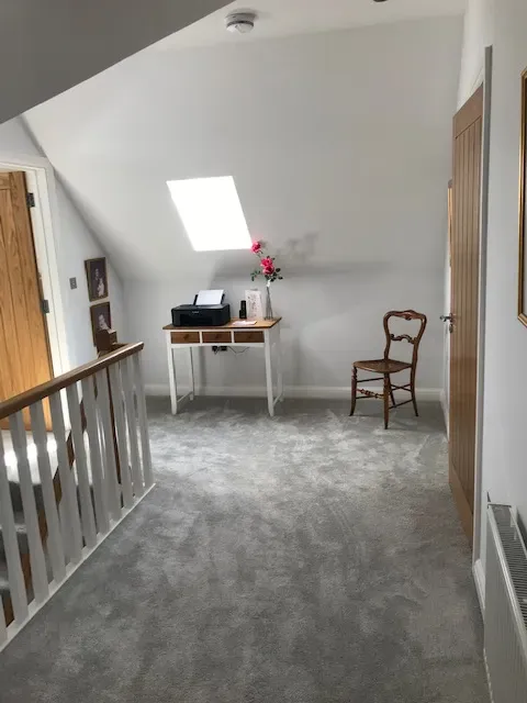 A hallway with a desk and chair in it
