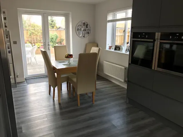 A kitchen with a table and chairs and a sliding glass door.