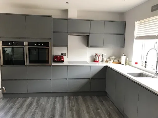 A kitchen with gray cabinets and stainless steel appliances