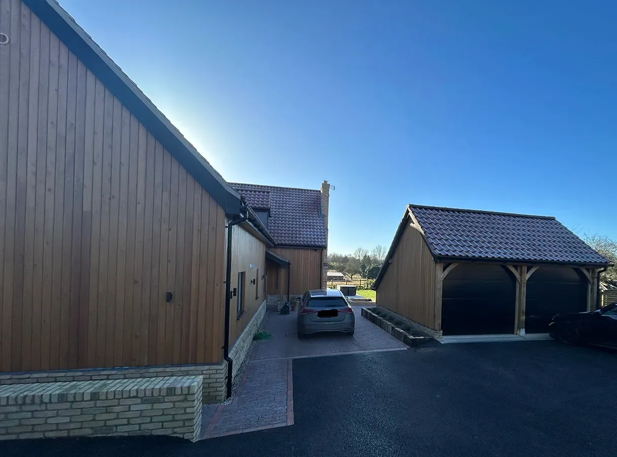 A car is parked in front of a wooden building.