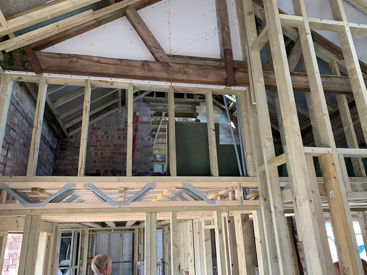 A man is standing in the middle of a building under construction.