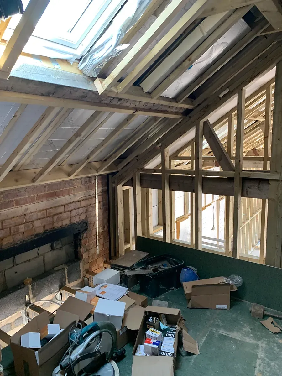 A room under construction with boxes and a bicycle on the floor.