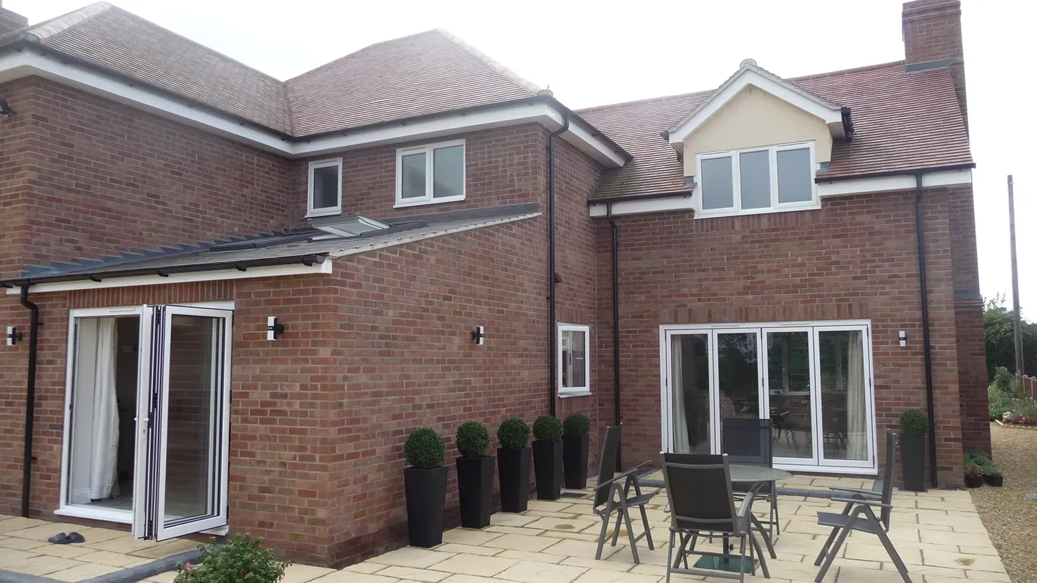 A large brick house with a patio in front of it
