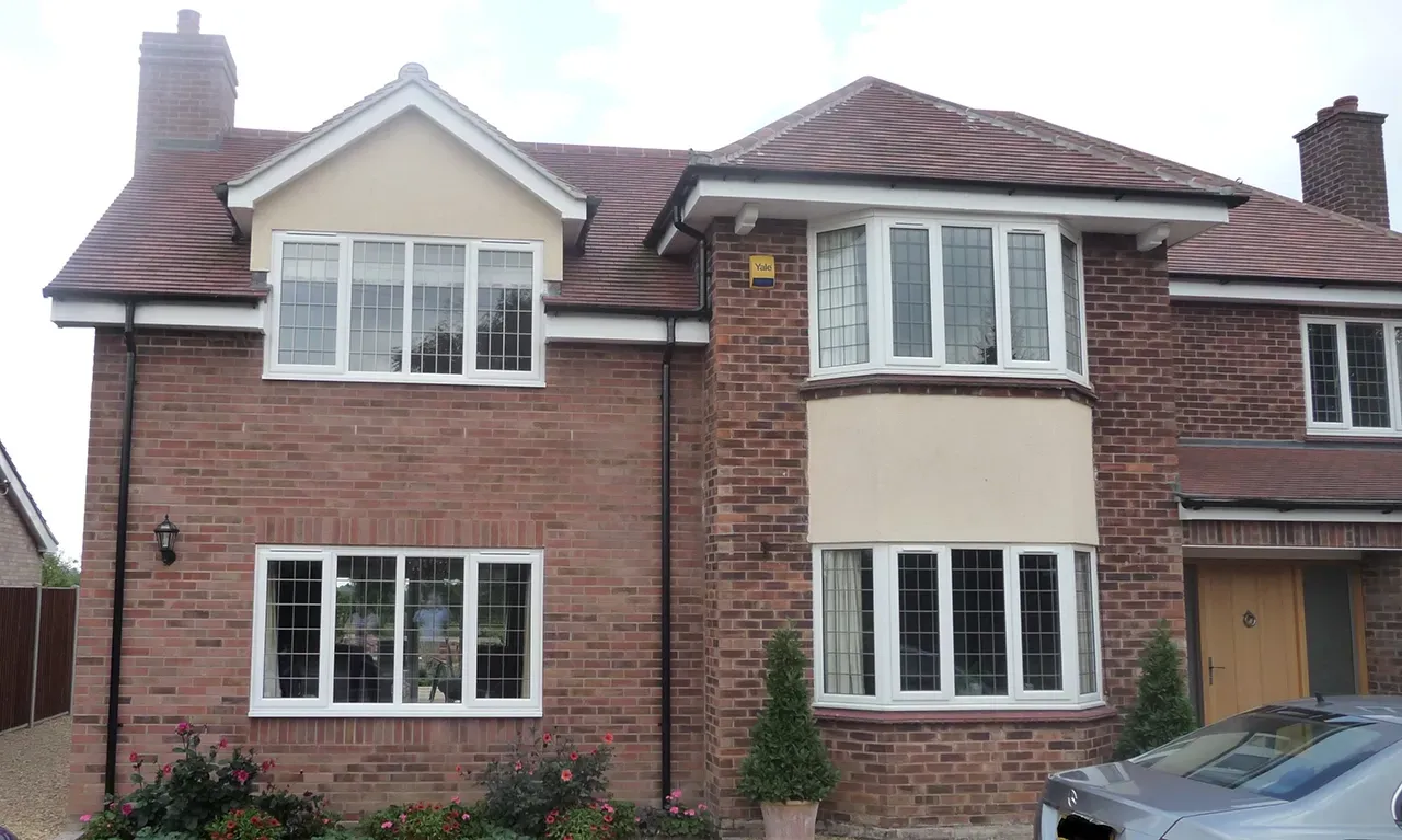 A large brick house with a car parked in front of it