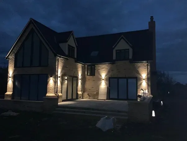 A large brick house is lit up at night