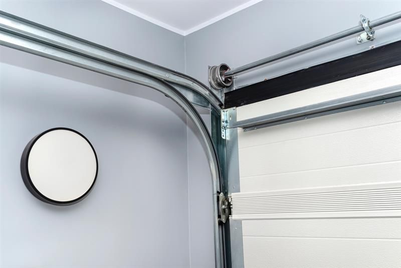 Garage door track bending, with roller; white door.