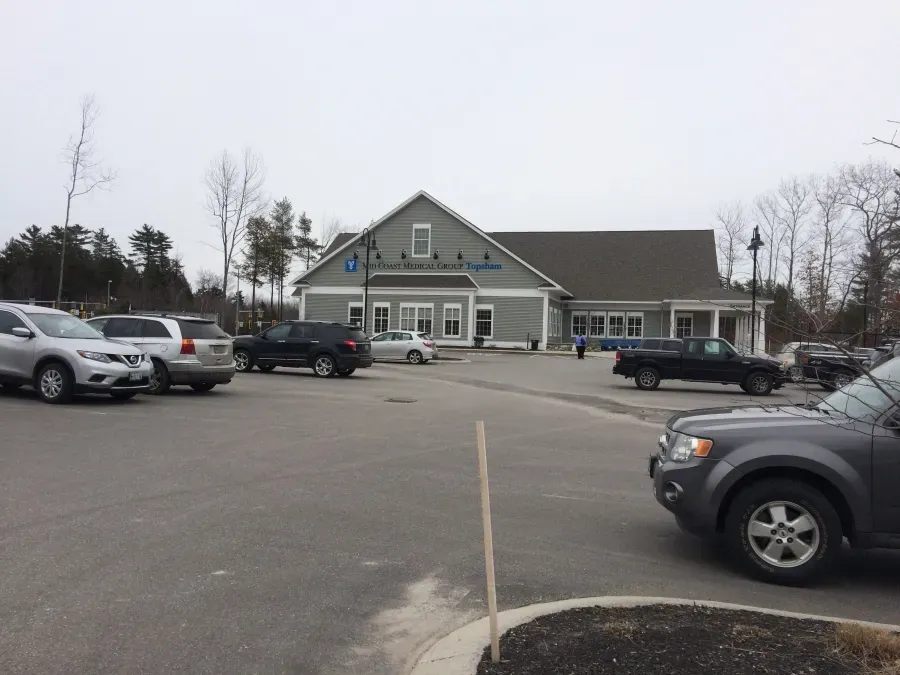 A lot of cars are parked in front of a building