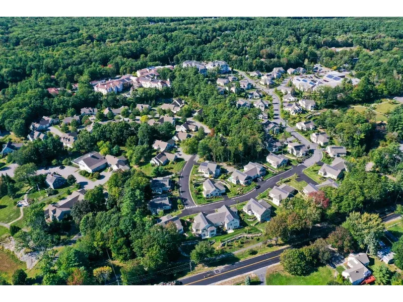 An aerial view of a residential area surrounded by trees and houses.