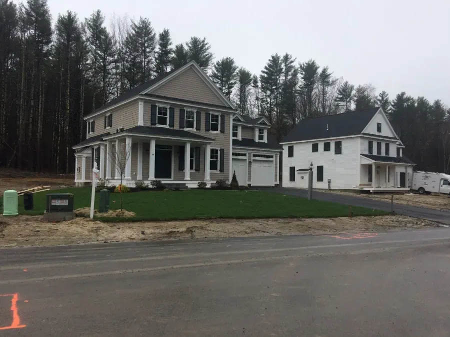 A couple of houses are sitting next to each other on the side of the road.