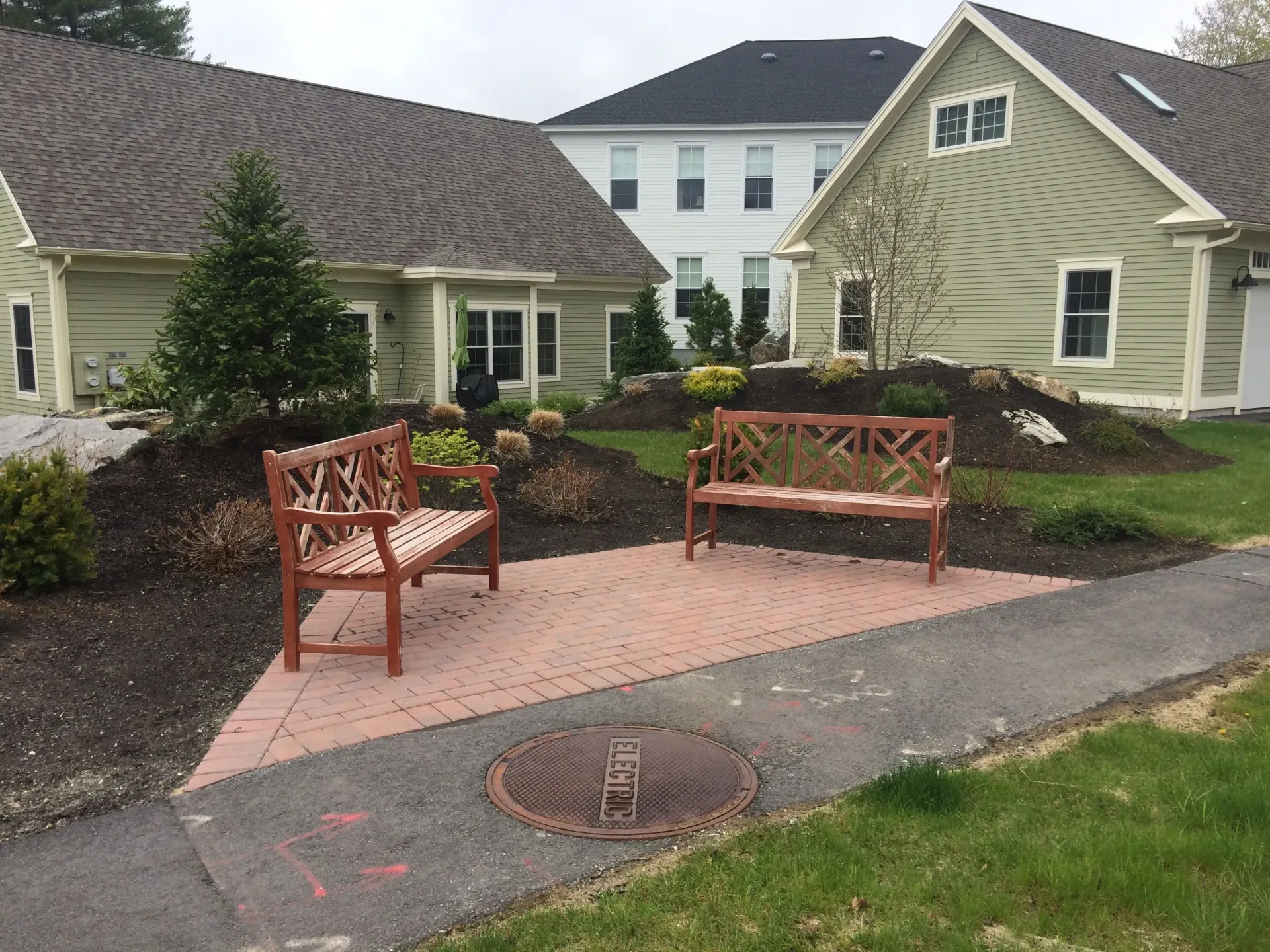 A couple of benches are sitting in front of a house.
