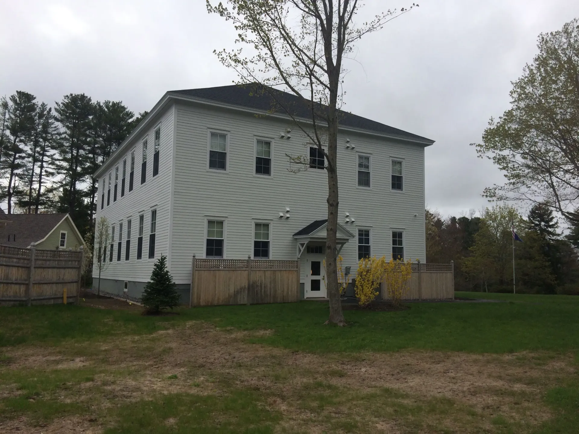 A large white house with a fence in front of it