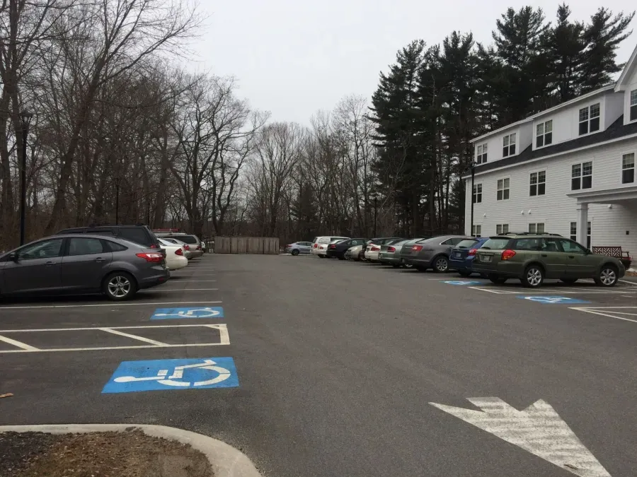 A row of cars are parked in a handicapped parking spot
