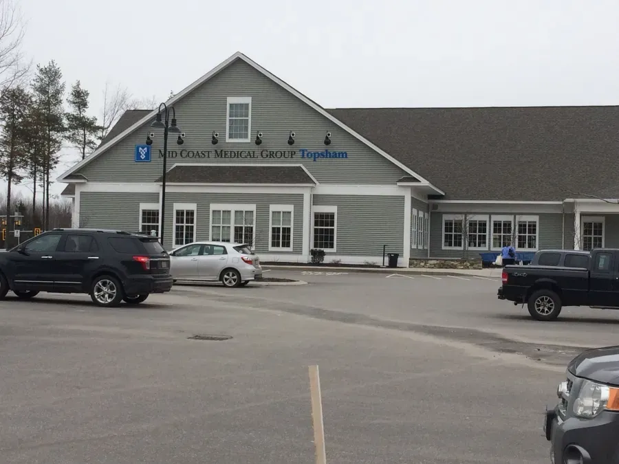 A large building with a lot of cars parked in front of it