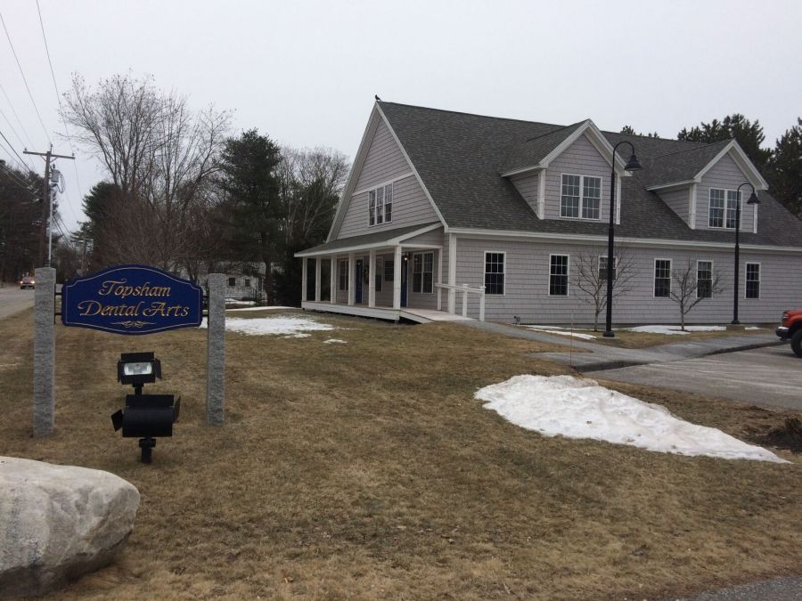 A house with a blue sign in front of it that says welcome dental arts