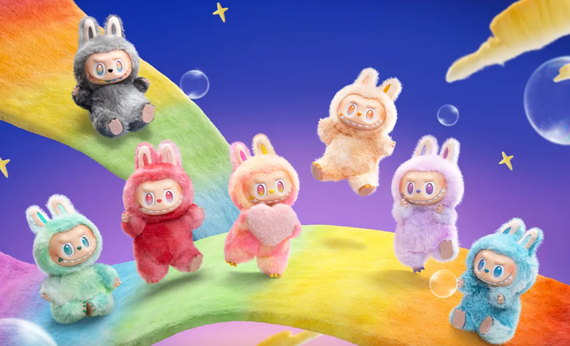Seven plush figures in bunny suits with rainbow background.
