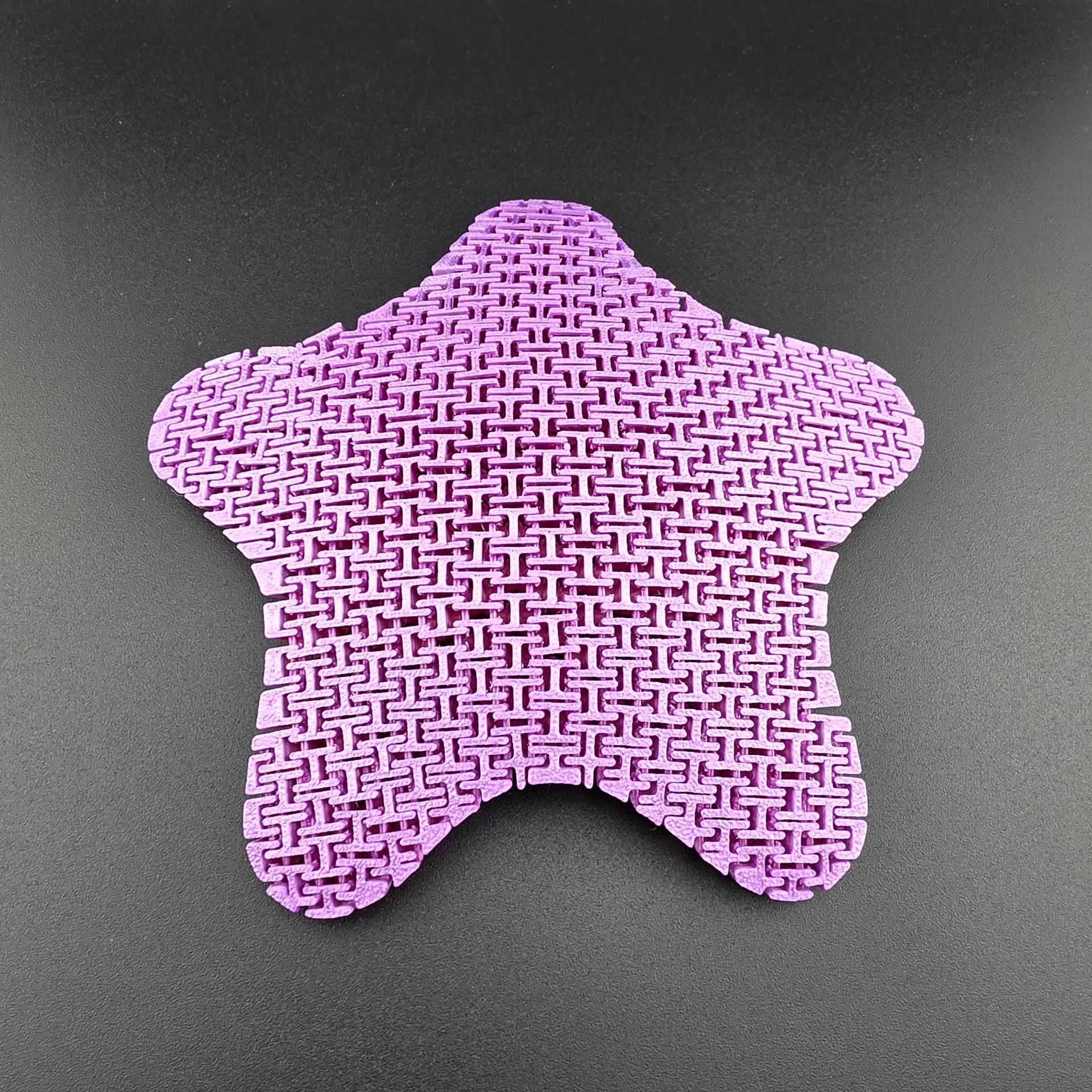 Colorful starfish toy with textured surface, rainbow hues, and orange trim.
