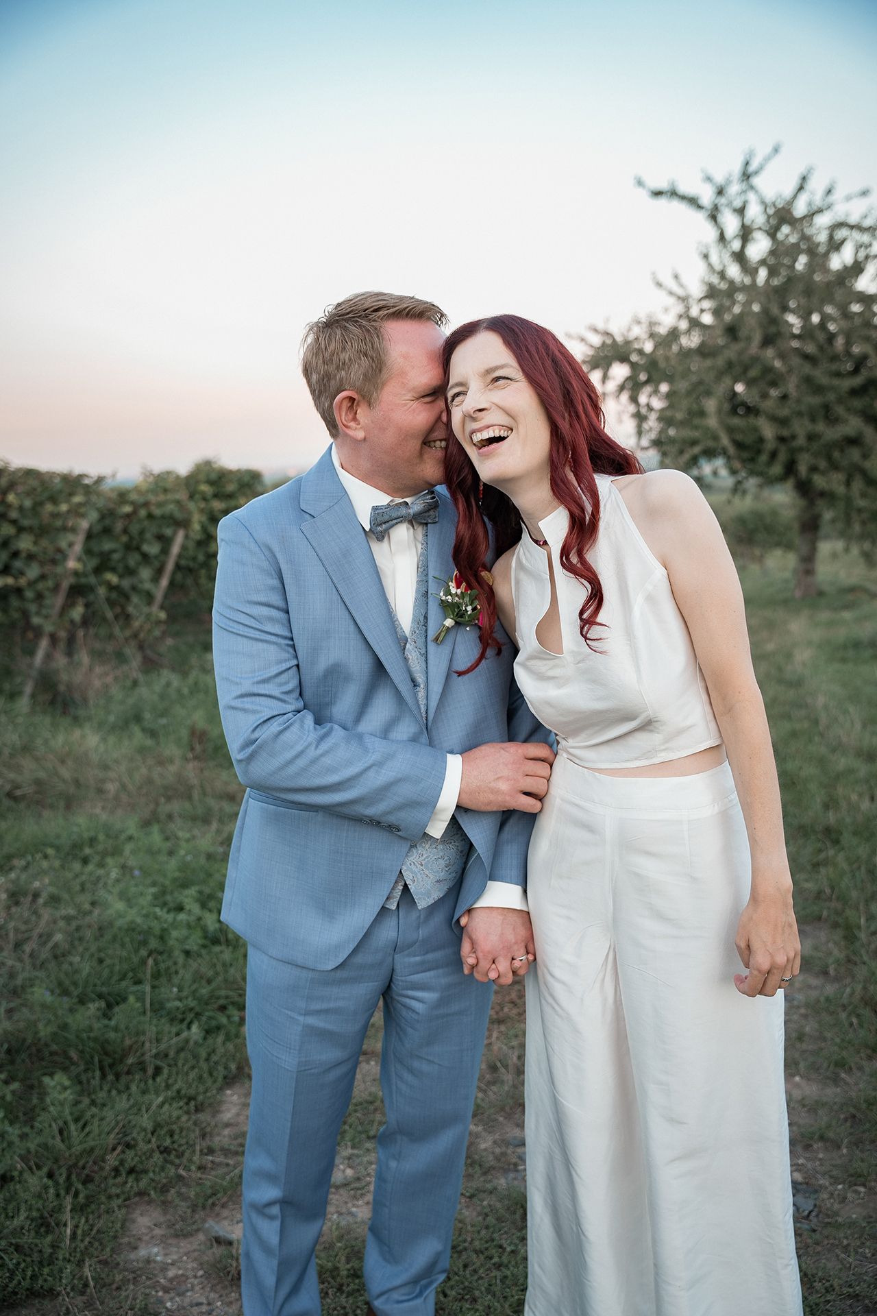 Bräutigam zieht Braut zu sich, sie lacht für unvergessliche Hochzeitsfotos