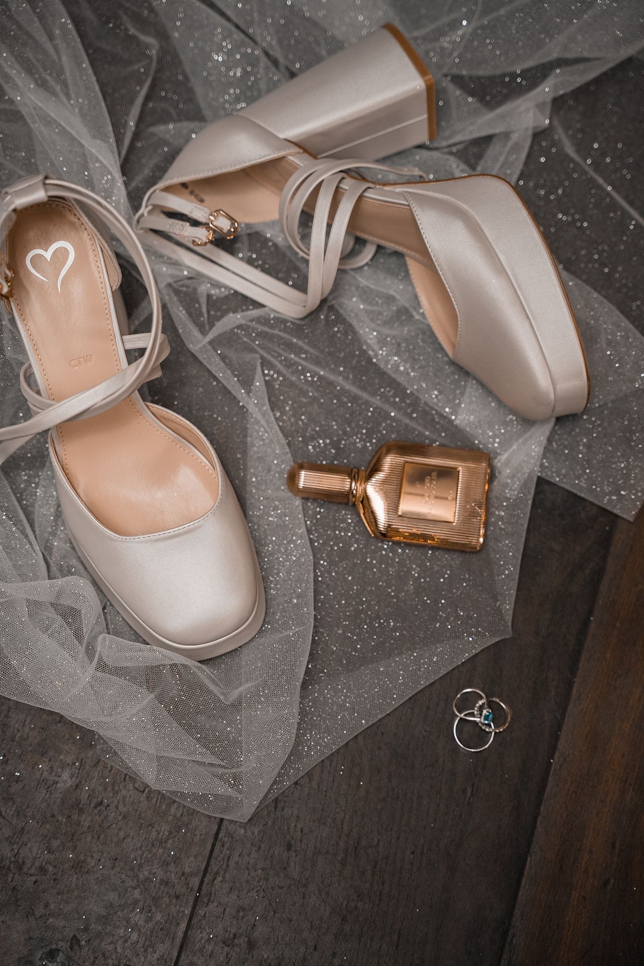 Flat Lay mit Brautschuhen, Eheringen und Parfum für Hochzeitsvorbereitungen
