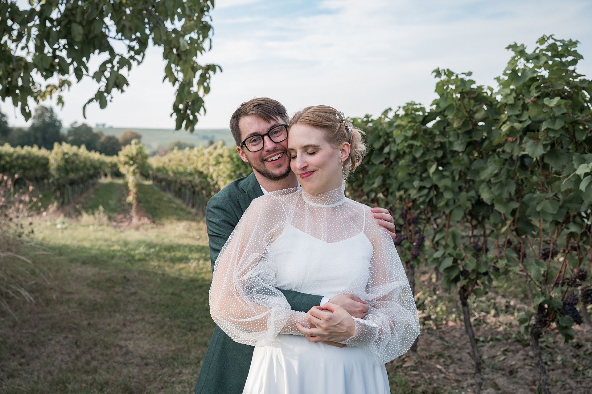 Hochzeitsfotograf Mainz - Brautpaar in Weinbergen umarmt sich, lacht in Kamera