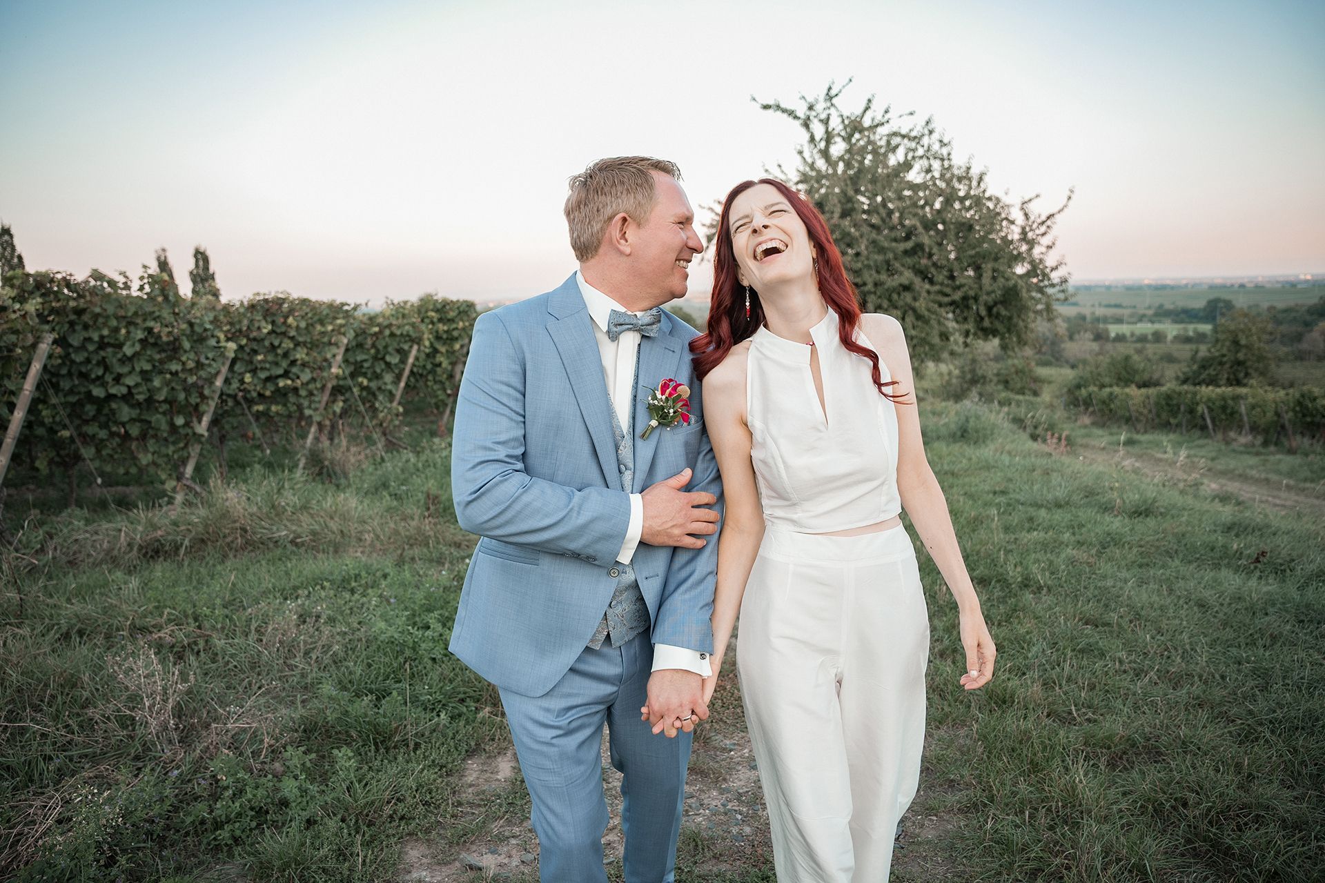 Hochzeitsfotograf Bad Kreuznach, Bräutigam flüstert Braut ins Ohr, sie lacht für fröhliche Hochzeitsfotos