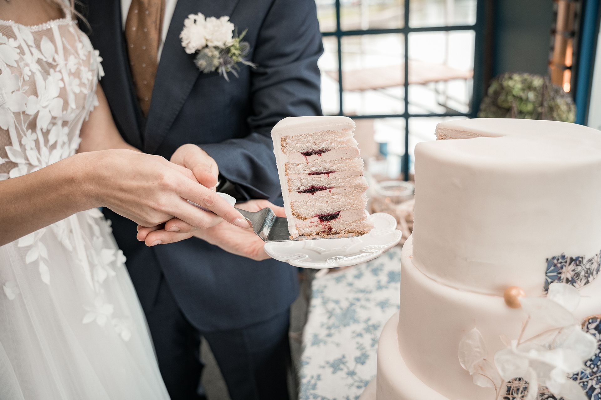 Hochzeitstortenstück wird aus der Torte genommen während Hochzeitsfeier in Frankfurt