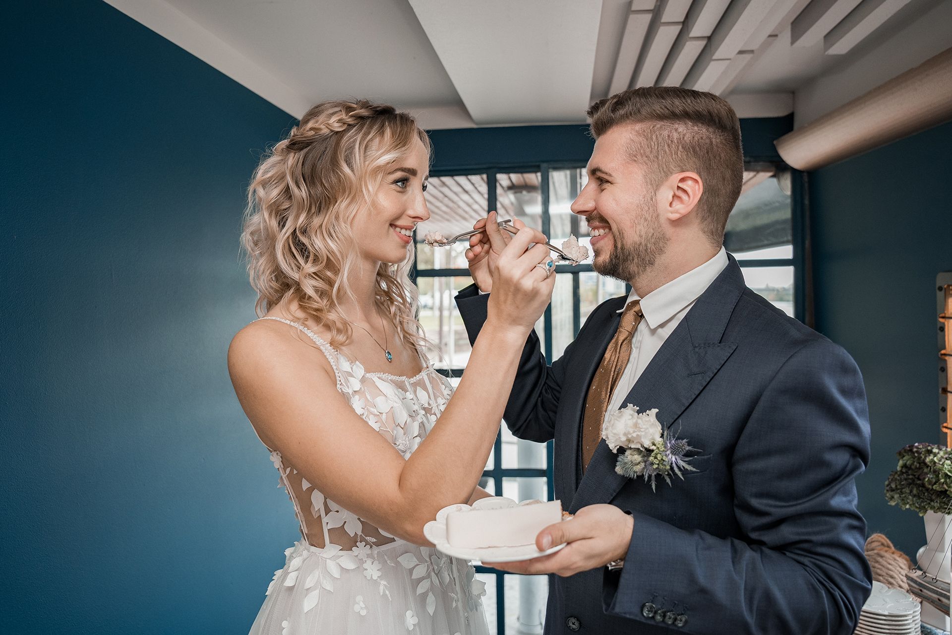 Brautpaar in Frankfurt füttert sich gegenseitig mit Hochzeitstorte während der Feier