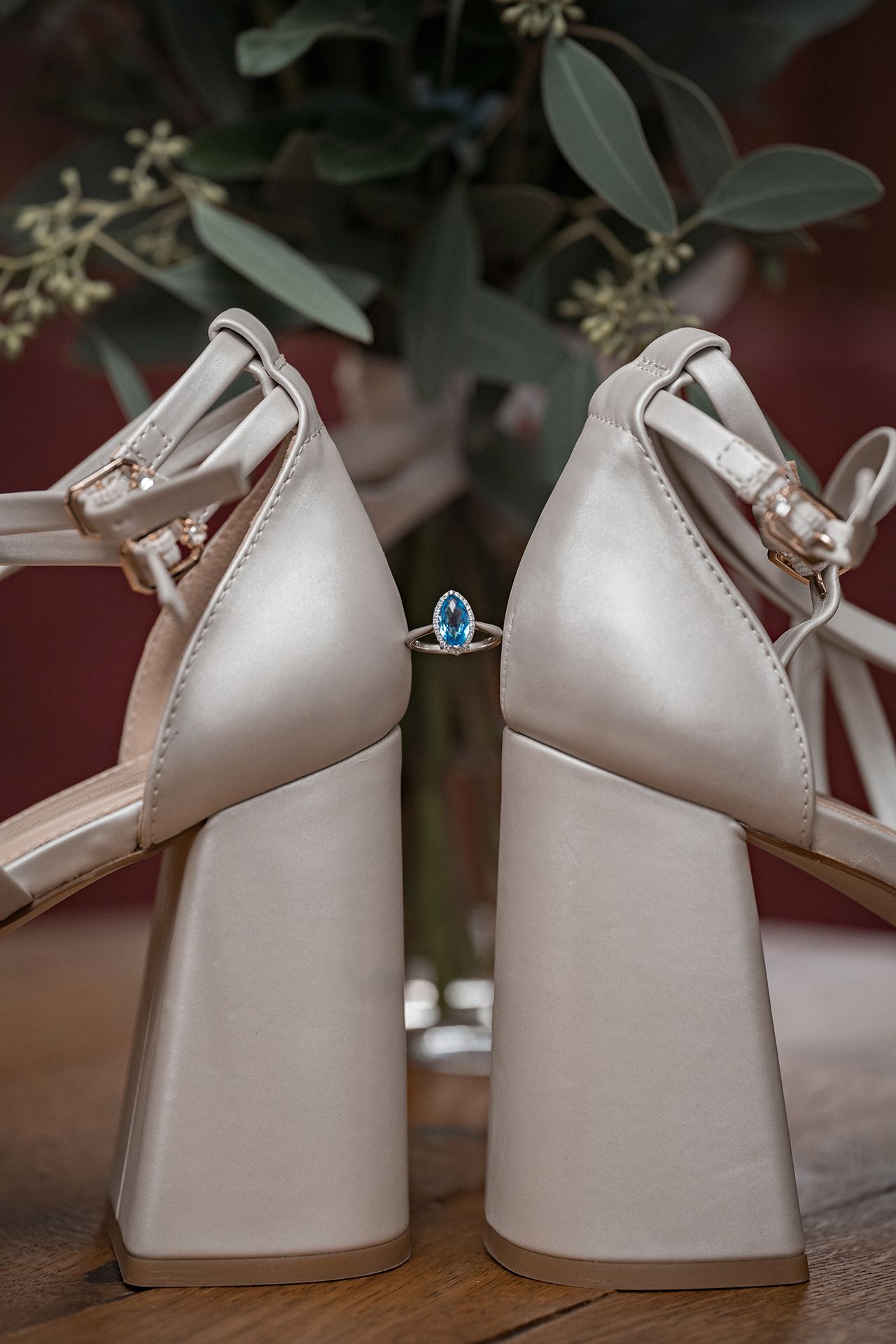 Brautschuhe von der Seite mit Ehering zwischen den Schuhen für Detailfotos