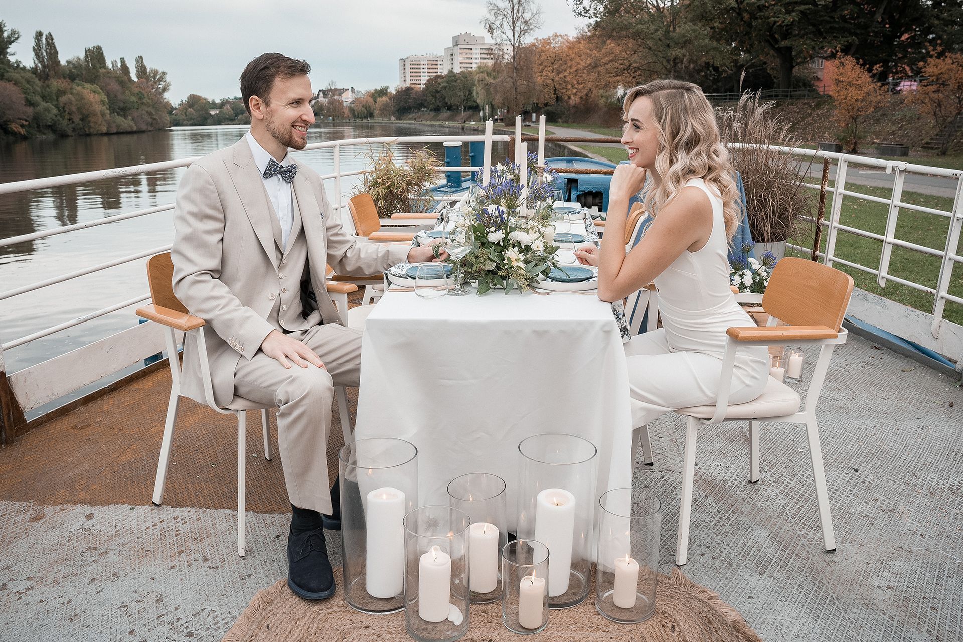 Hochzeitsfotografie Frankfurt - Braut und Trauzeuge auf Schiffsdeck an blau-weiß gedecktem Tisch