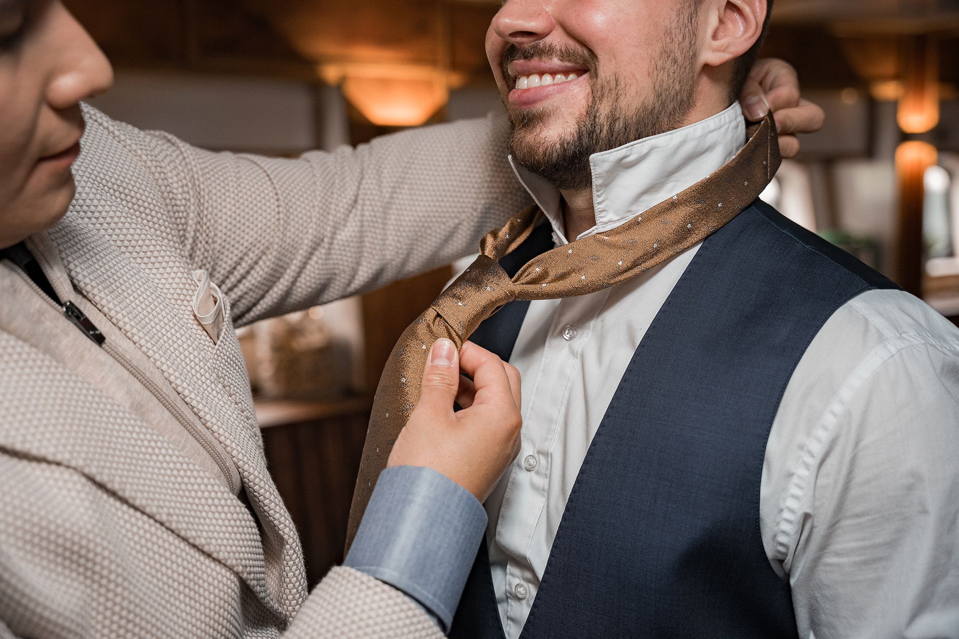 Bräutigam beim Getting Ready in Frankfurt, Trauzeuge richtet Krawatte