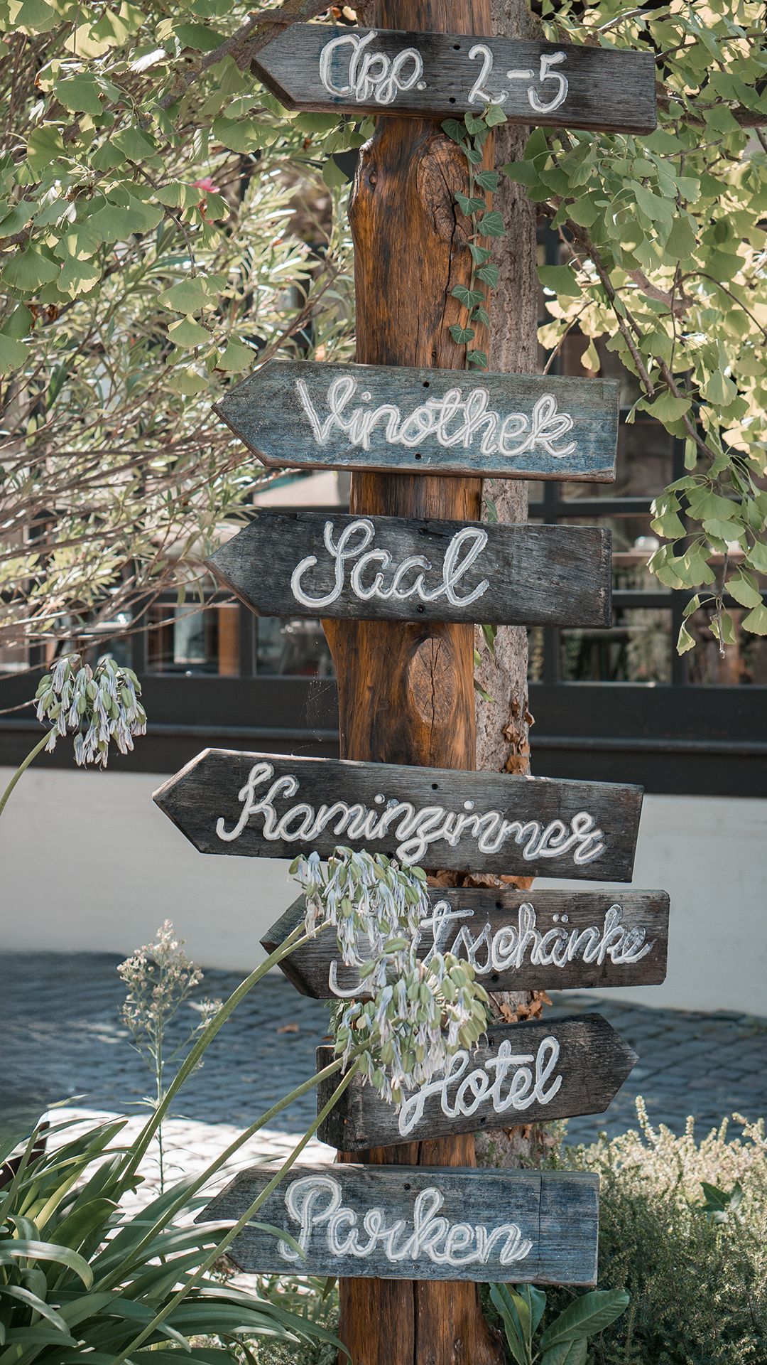 Battenheimer Hof - Holz-Wegweiser mit Aufschriften in mediterraner Hochzeitslocation