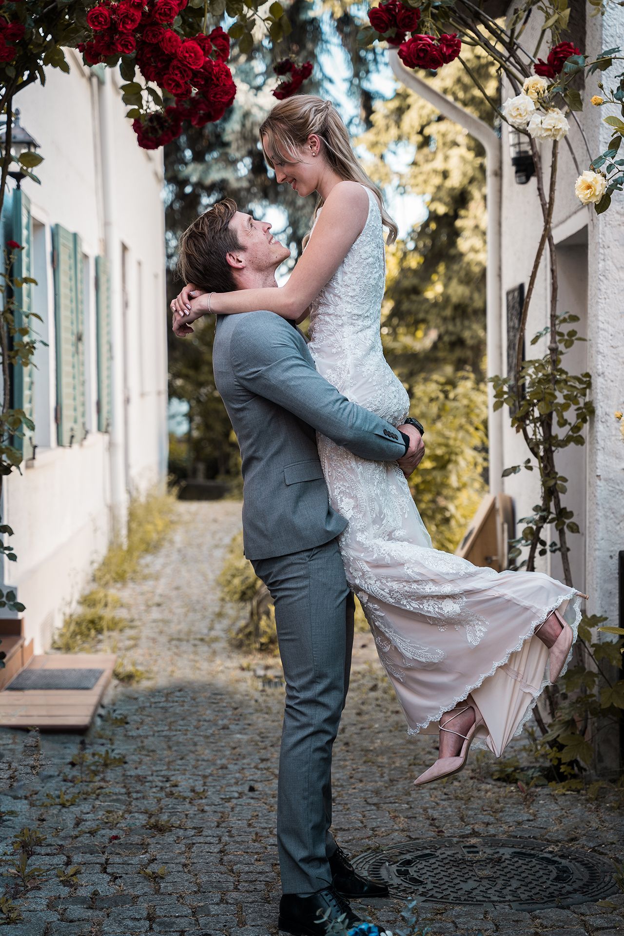Hochzeitsfotograf Ingelheim, Brautpaar unter Rosenbogen in romantischer Gasse für Hochzeitsfotos