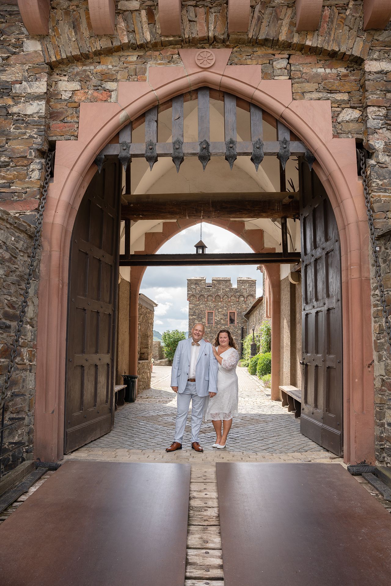Hochzeitsfotograf Burg Reichenstein, Brautpaar unter dem Torbogen für romantische Hochzeitsfotos