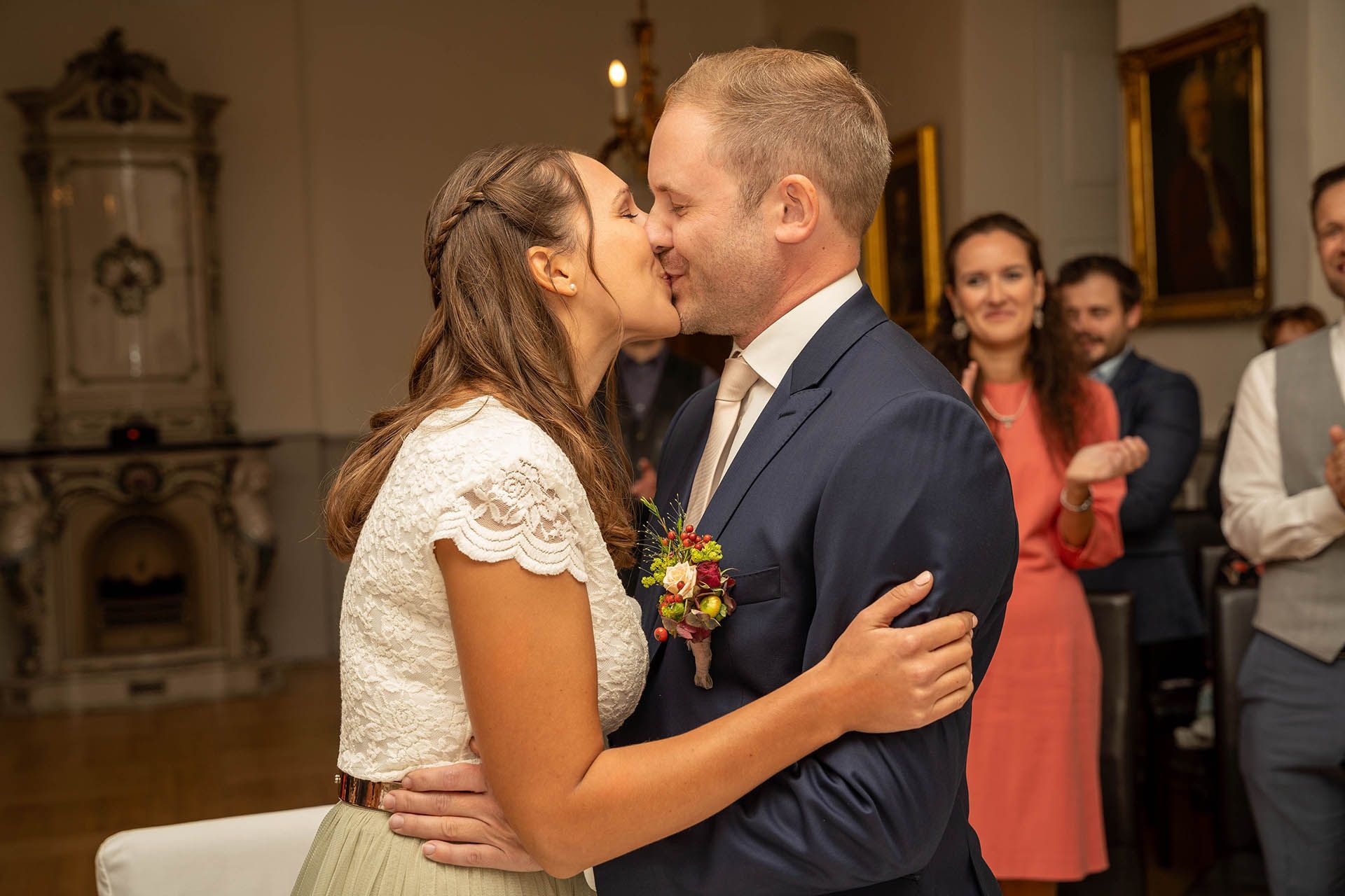 Braut und Bräutigam teilen ihren ersten Kuss während der Trauung in Eltville, umgeben von Freunden und Familie