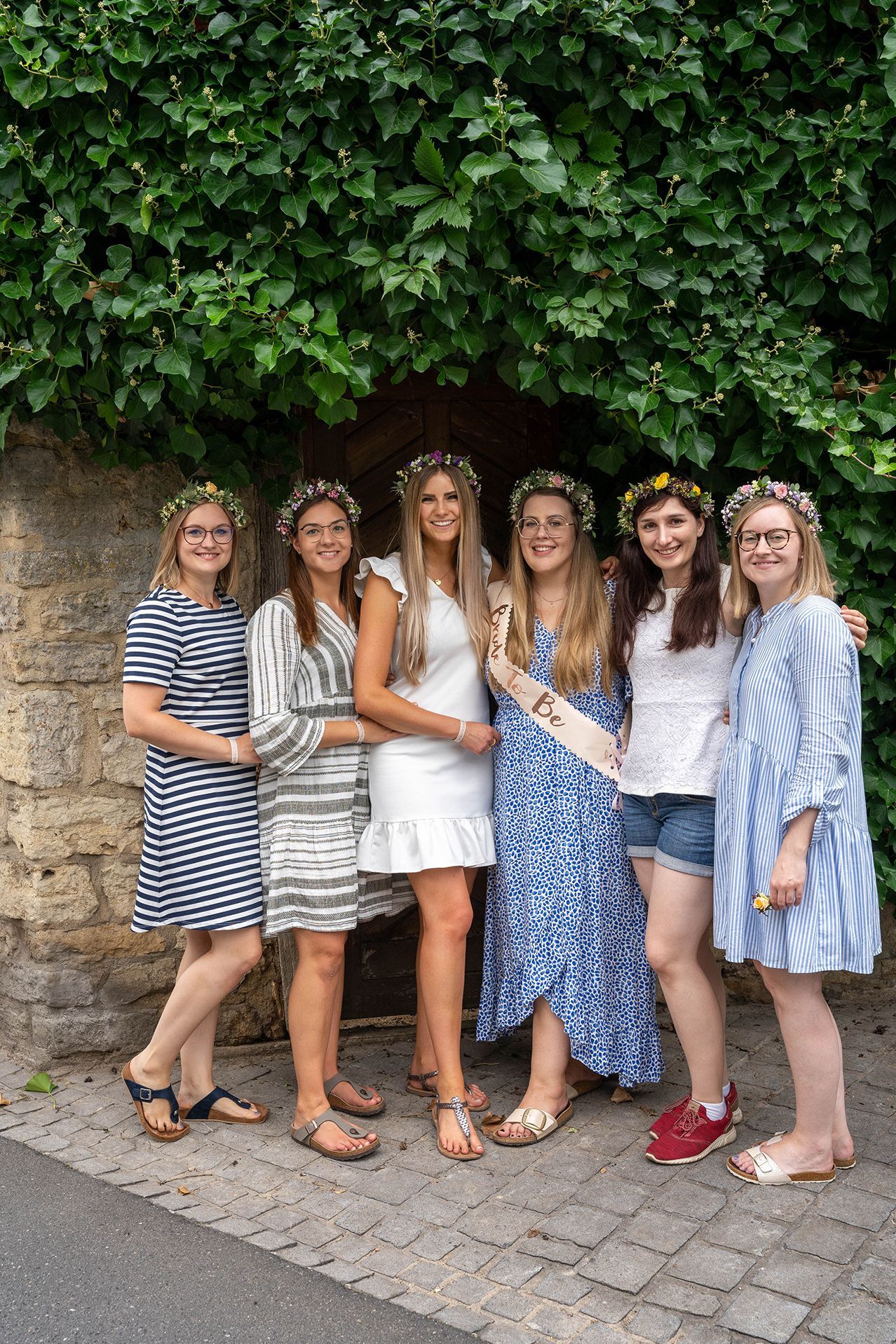 JGA Shooting in Ingelheim – Braut und Mädels vor Holztor mit Efeu, fröhlich lachend