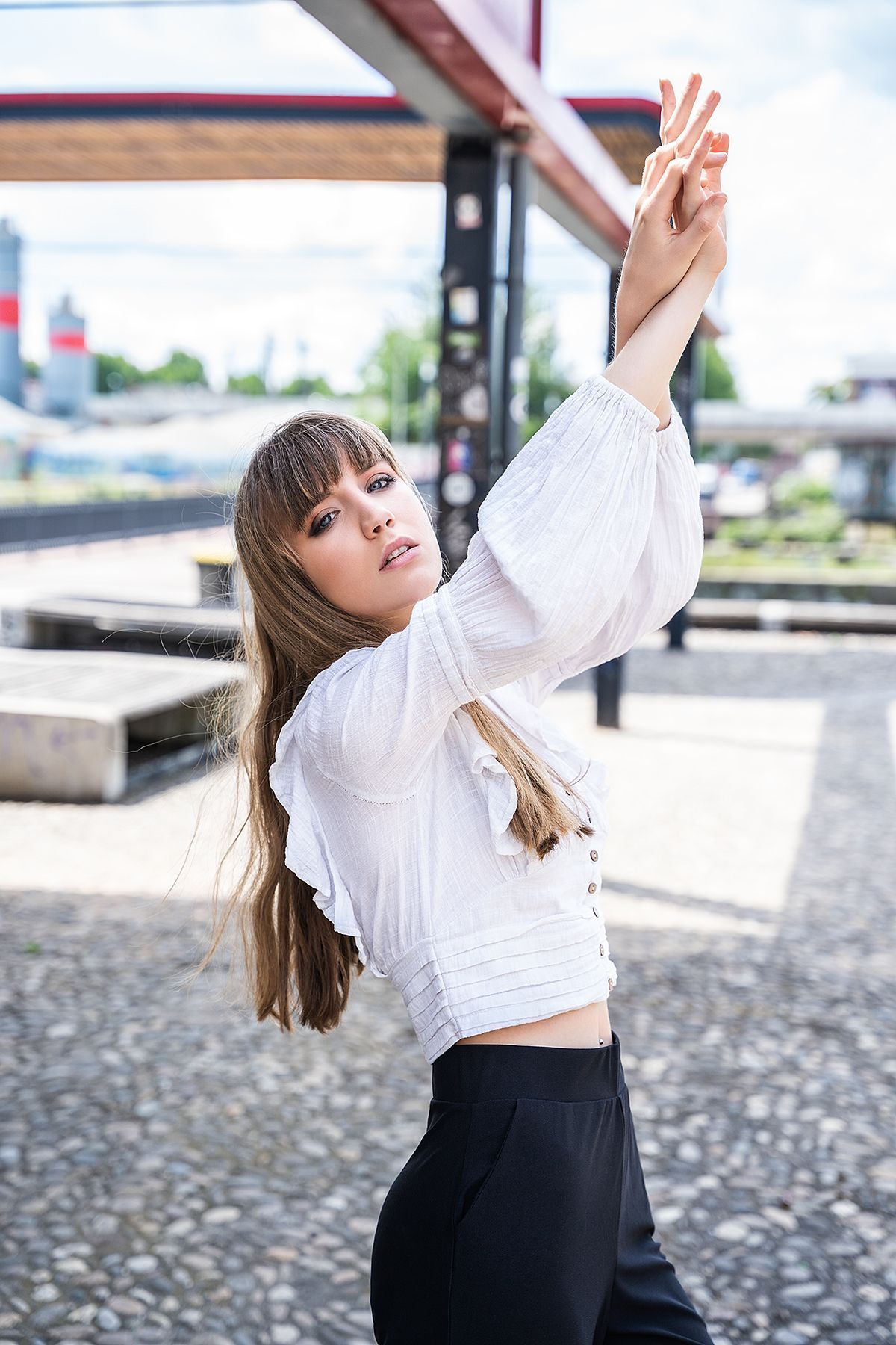 Kreatives Portrait einer Frau, Arme in Pose vor Metallgestell in Bad Kreuznach
