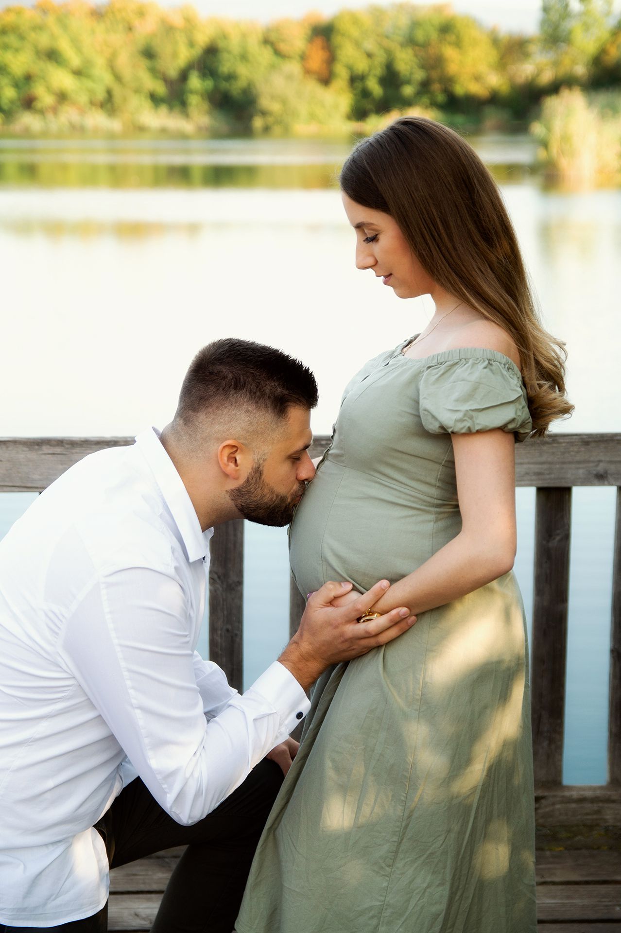 Babybauch Fotos in Wiesbaden – Mann küsst Bauch der Frau auf Steg