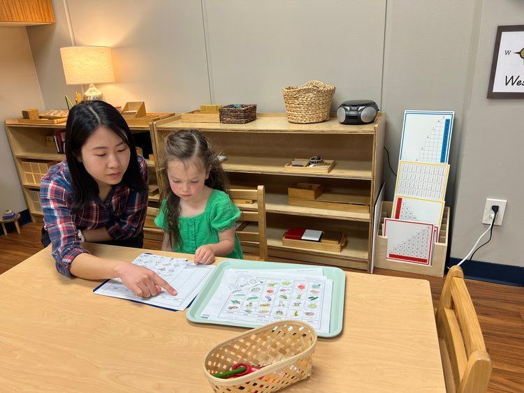 A woman is helping a little girl with her homework