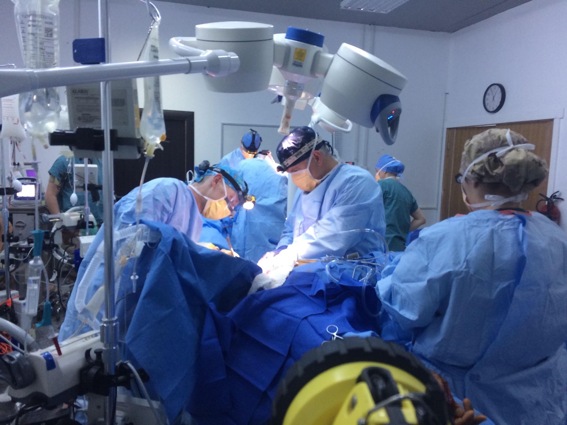 A group of surgeons are operating on a patient in an operating room.