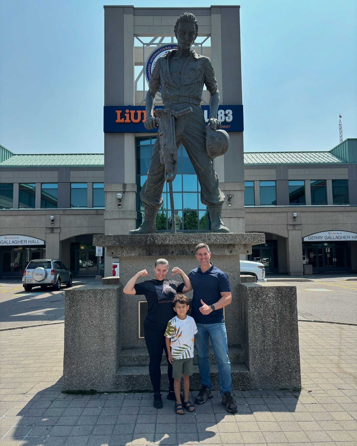 A group of people are posing for a picture in front of a statue.