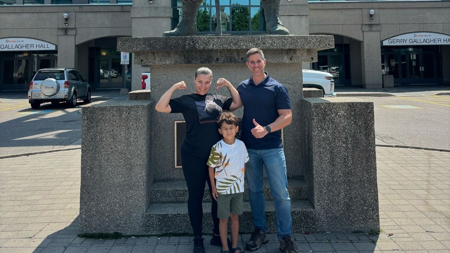 A family is posing for a picture in front of a statue.